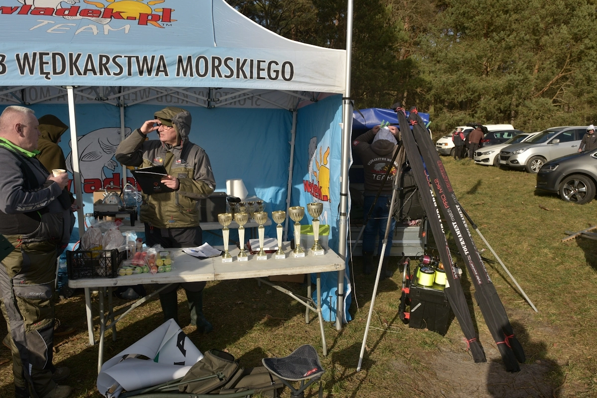 Łąka w miejscowości Karwieńskie Błoto otoczona lasem i rozstawianie sprzętu uczestników zawodów rzutowych