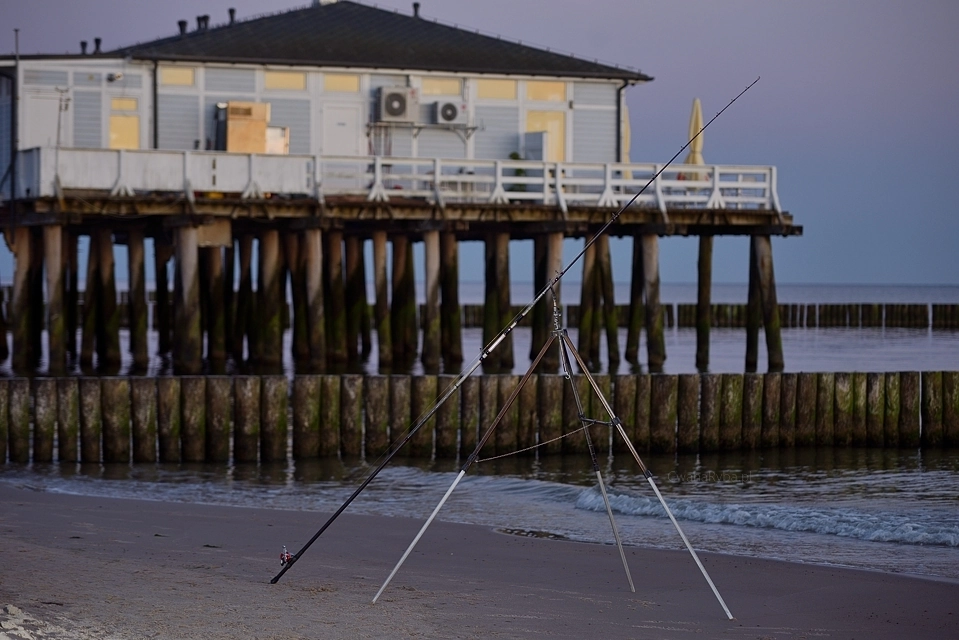 Tripod wędkarski plażowy i oparta o niego wędka morska
