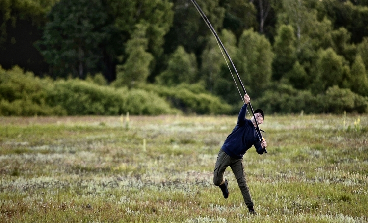 Zawodnik rzucający wędką na polu turniejowym