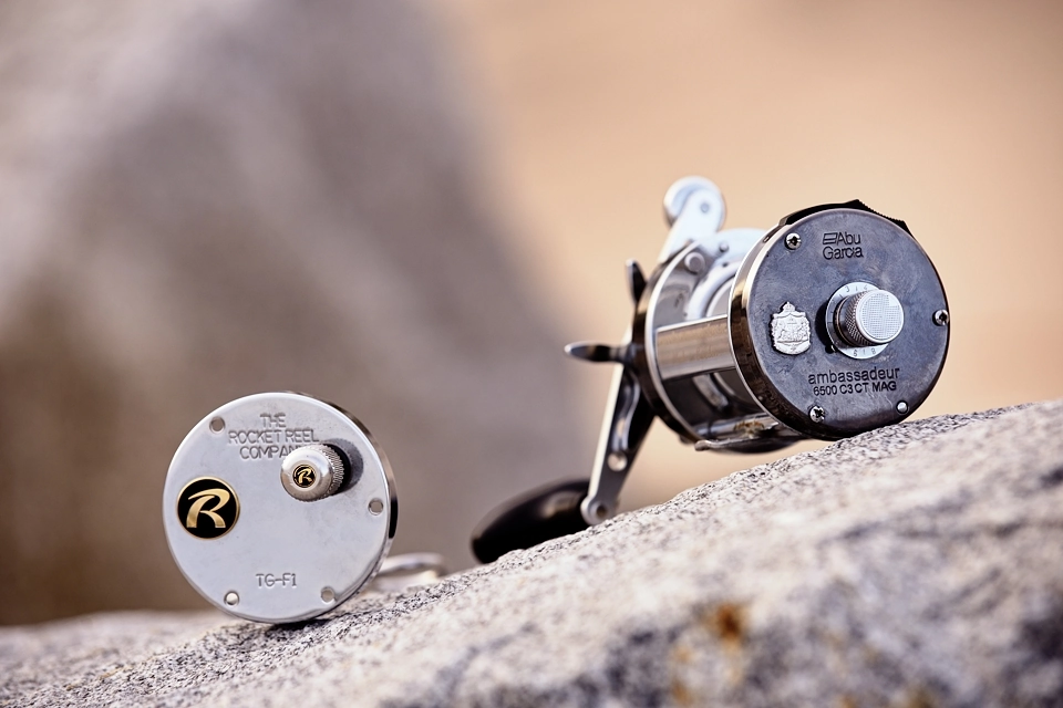 Kołowrotek wędkarski z elementem bocznej płyty na skałach wybrzeża